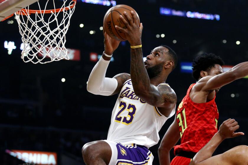 Los Angeles Lakers' LeBron James (23) shoots past Atlanta Hawks's Damian Jones (30) during the first half of an NBA basketball game, Sunday, Nov. 17, 2019, in Los Angeles. (AP Photo/Ringo H.W. Chiu)