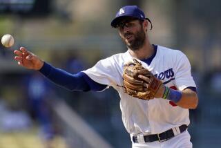 Los Angeles Dodgers second baseman Chris Taylor throws to first base during a baseball game.