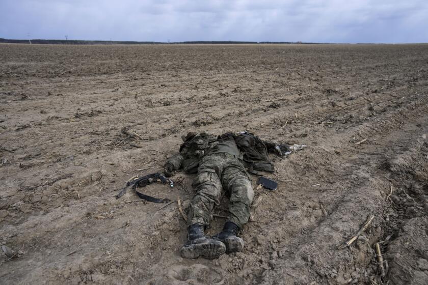 FILE - A Russian soldier killed during combats against Ukrainian army lies on a corn field in Sytnyaky, on the outskirts of Kyiv, Ukraine, Sunday, March 27, 2022. Nearly 50,000 Russian soldiers have died in the war in Ukraine, according to a new statistical analysis. (AP Photo/Rodrigo Abd, File)