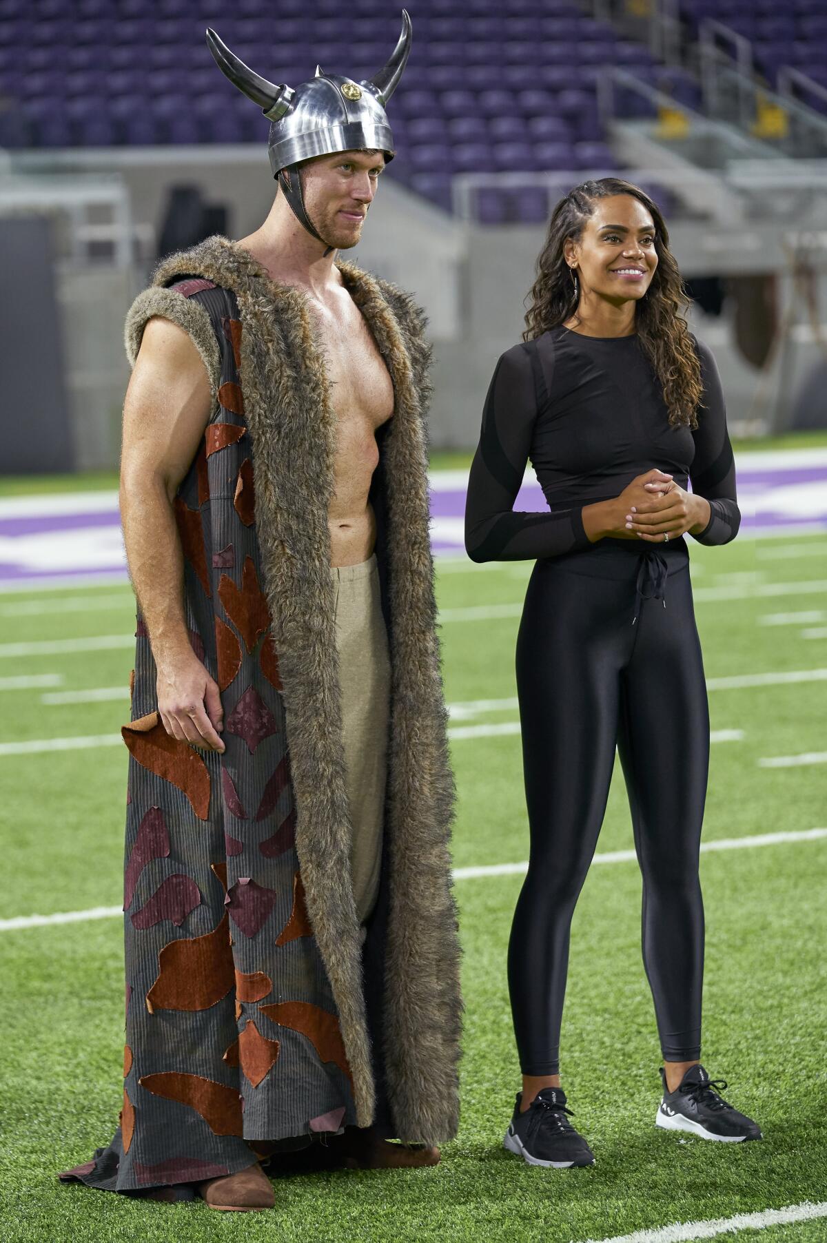 A man in a silly Viking costume standing next to a woman in spandex.