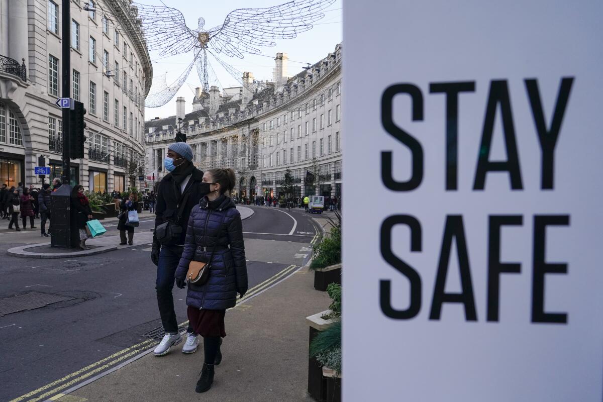 FILE - People wear face masks as they walk, in Regent Street, in London, Sunday, Nov. 28, 2021. The number of new coronavirus cases across Britain has surged by more than 30% in the last week, with cases largely driven by the super infectious omicron variants. Data released by Britain’s Office for National Statistics on Friday, July 1, 2022 showed that more than 3 million people in the U.K. had COVID-19 last week, although there has not been an equivalent spike in hospitalizations. (AP Photo/Alberto Pezzali, File)