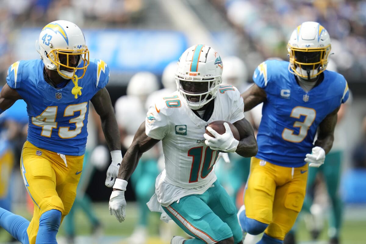 Miami Dolphins wide receiver Tyreek Hill is pursued by Chargers cornerback Michael Davis (43) and safety Derwin James Jr.
