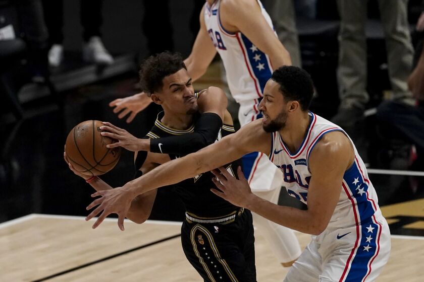 76ers guard Ben Simmons tries to steal the ball from Hawks guard Trae Young.
