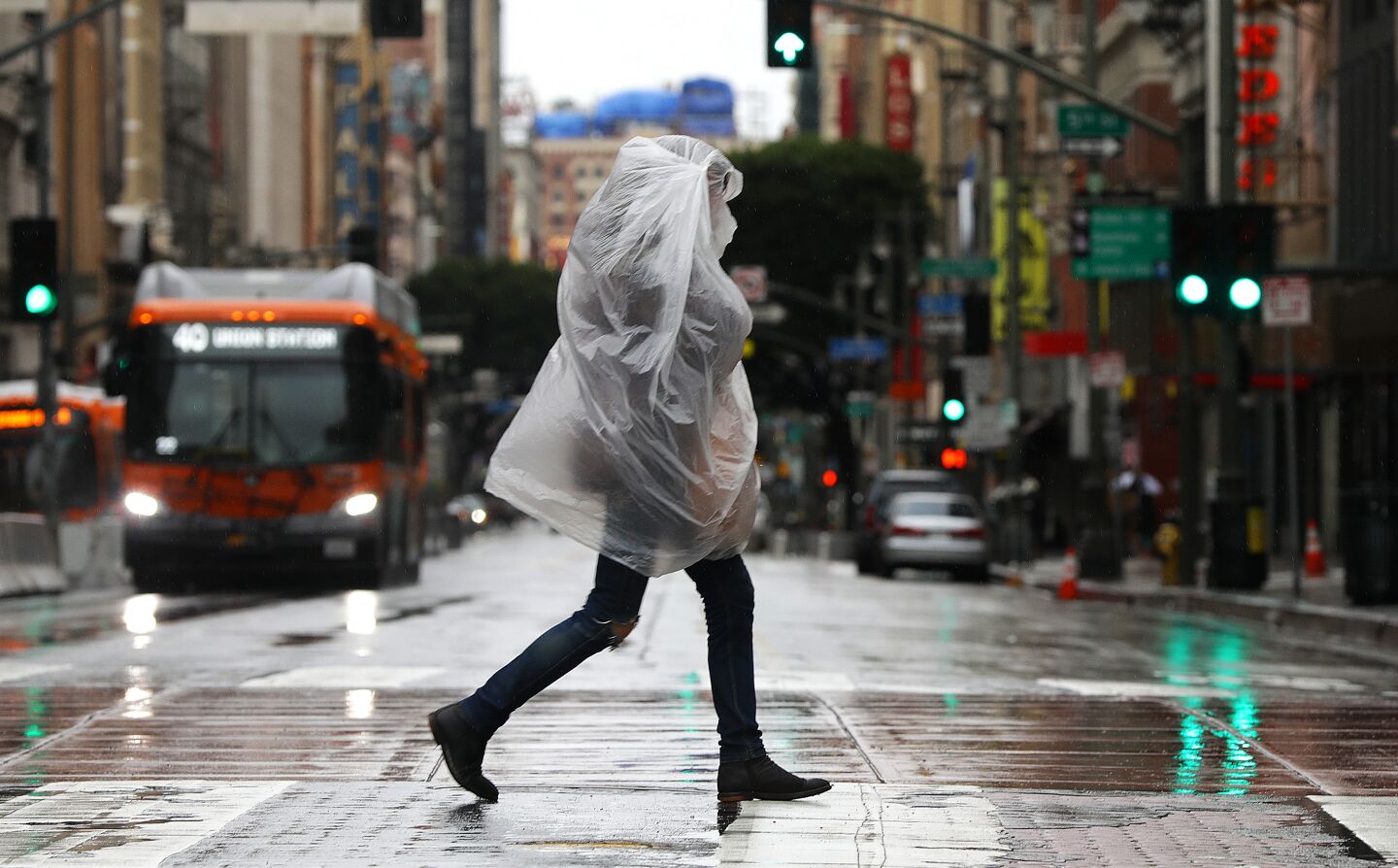 A pedestrian takes cover from the rain in downtown Los Angeles.