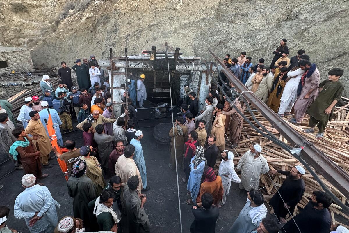 People gather as rescue workers attempt to reach miners trapped in a coal mine