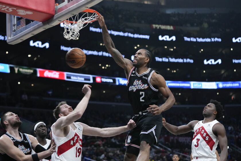 Los Angeles Clippers' Kawhi Leonard (2) dunks over Toronto Raptors' Jakob Poeltl (19) during second half of an NBA basketball game Wednesday, March 8, 2023, in Los Angeles. (AP Photo/Jae C. Hong)