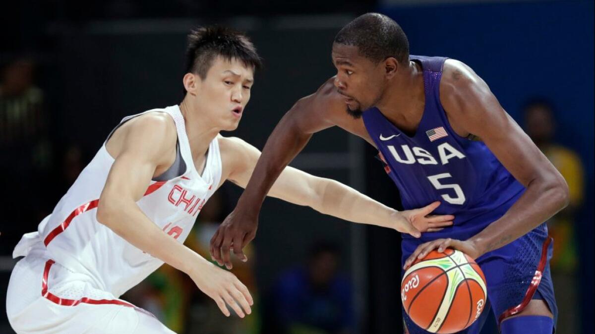 Team USA forward Kevin Durant works against China's Peng Zhou during a Group A match in the Olympic men's basketball tournament.