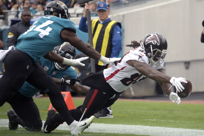 El corredor de los Falcons de Atlanta Cordarrelle Patterson salta para el touchdown superando al linebacker de los Jaguars de Jacksonville Myles Jack en el encuentro del domingo 28 de noviembre del 2021. (AP Photo/Phelan M. Ebenhack)