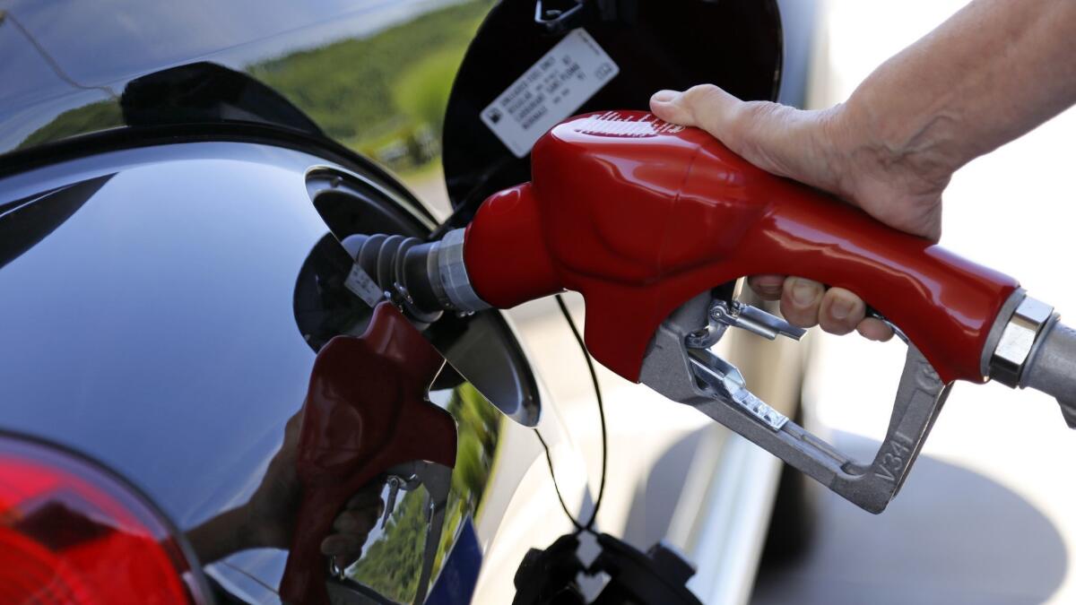 In this July 16, 2015, file photo, a customer refuels her car at a Costco in Robinson Township, Pa. The Trump administration plans to roll back efforts to increase the fuel economy of U.S. cars and light trucks.