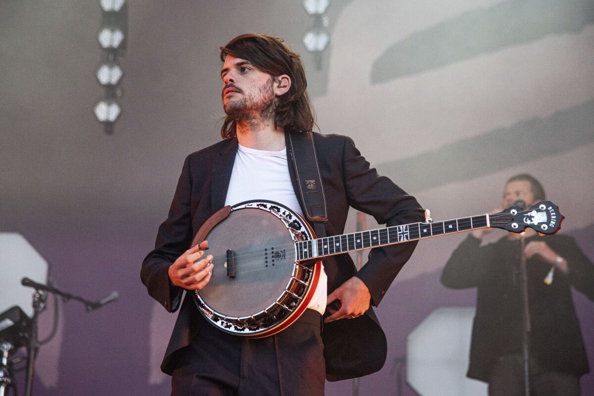 A man with a banjo stands on a stage