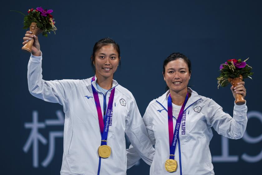 Taiwan's Chan Hao-ching and Chan Yung-jan celebrate with their gold medals after the tennis women's doubles final at the 19th Asian Games in Hangzhou, China, Saturday, Sept. 30, 2023. (AP Photo/Louise Delmotte)