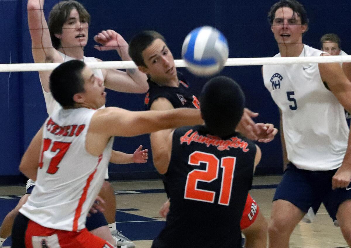 Huntington Beach's Aiden Atencio (17) and Bennet Tchaikovsky (21) try to keep the ball in play against Newport Harbor.