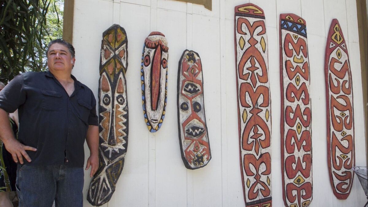 Escondido artist Bosko Hrnjak with some of his wood tiki wall decorations.