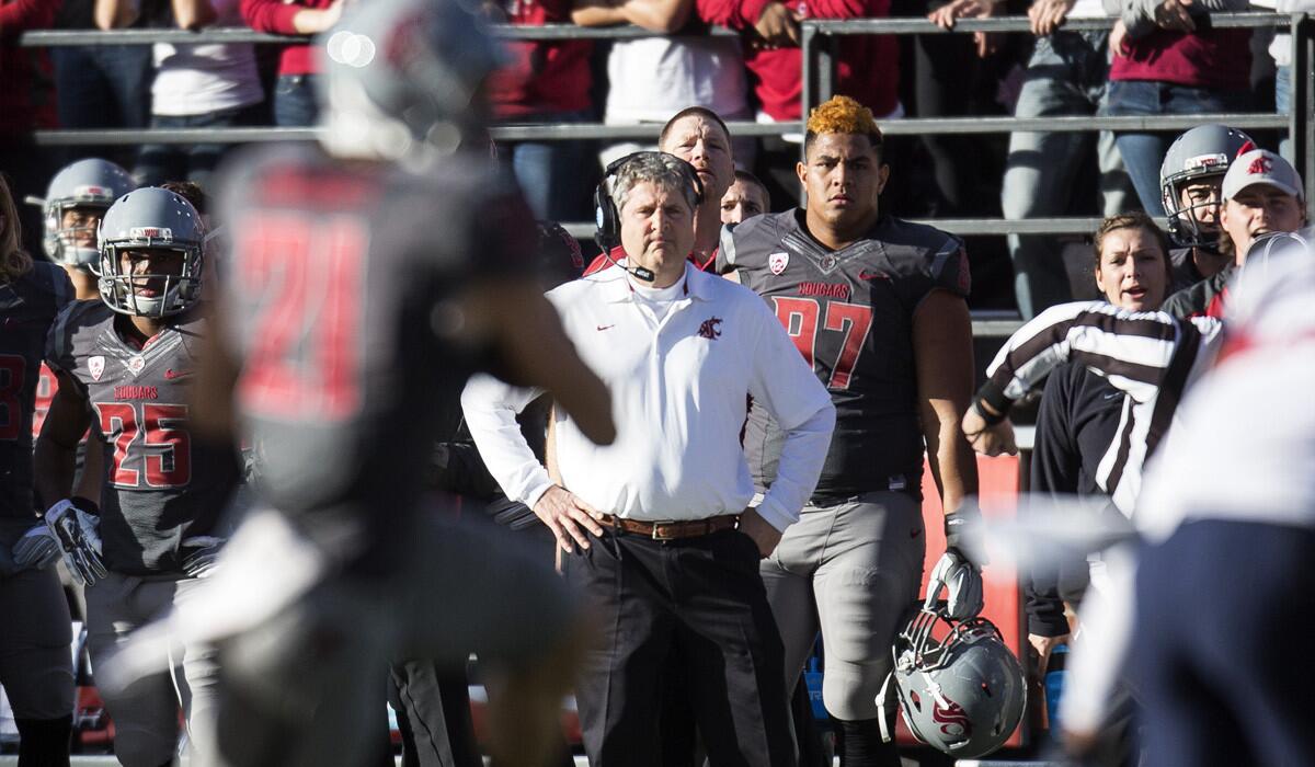 Washington State Coach Mike Leach (in white) watches as wide receiver River Cracraft (21) catches a pass from Connor Halliday during their game against Arizona.