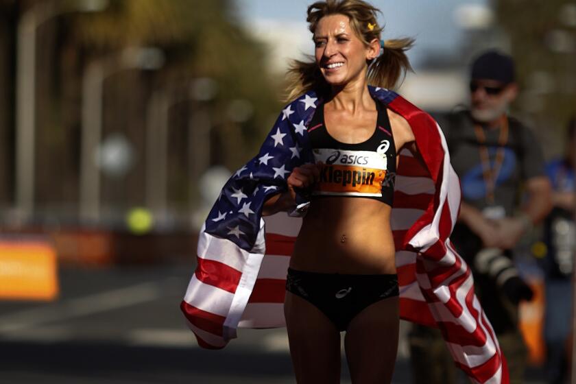 Lauren Kleppin of Mammoth Lakes parades with the American flag after winning third place in the women's division of the 29th annual L.A. Marathon.
