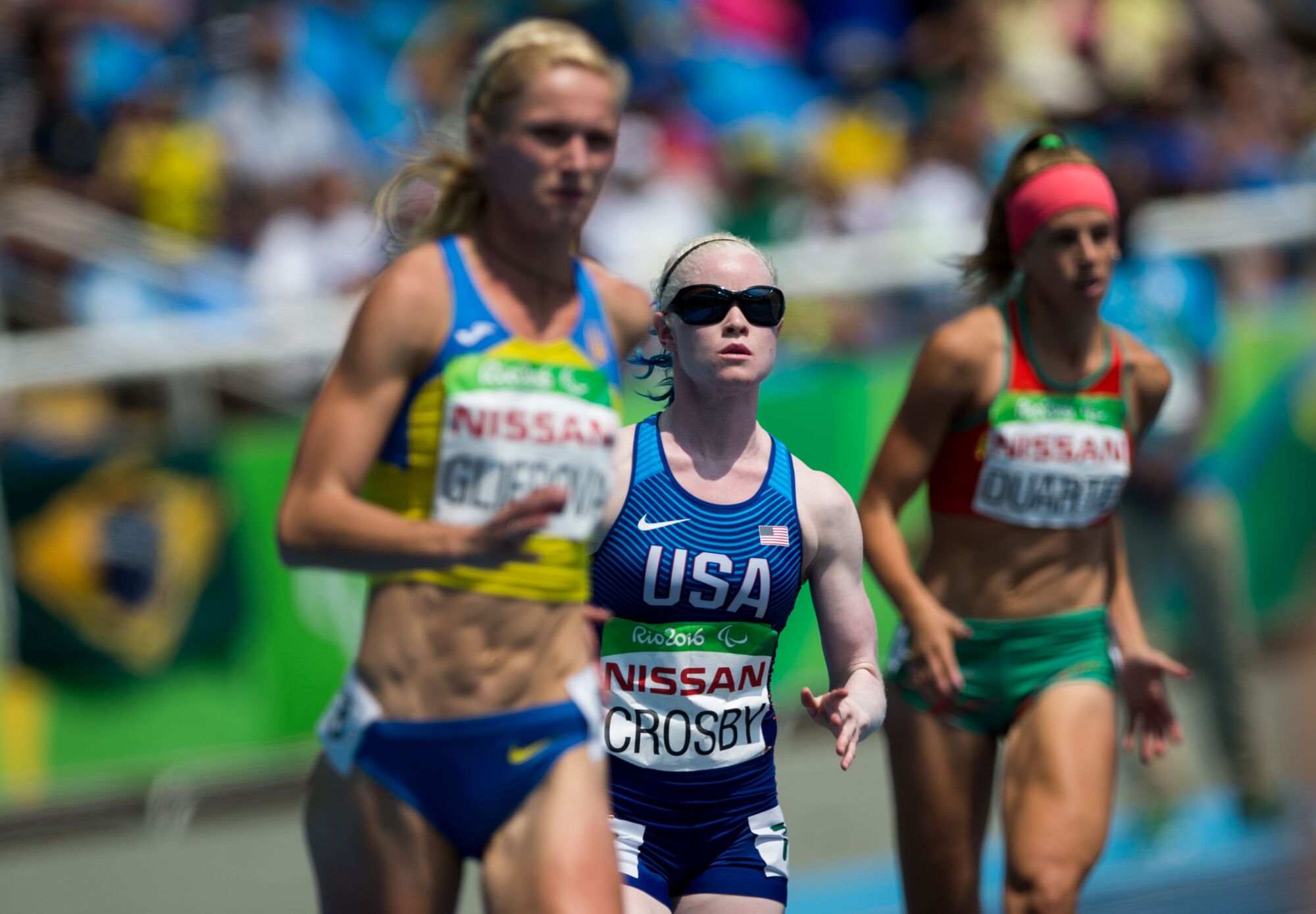 U.S. runner Kym Crosby runs between two other athletes at the 2016 Paralympics in Rio de Janeiro, Brazil.