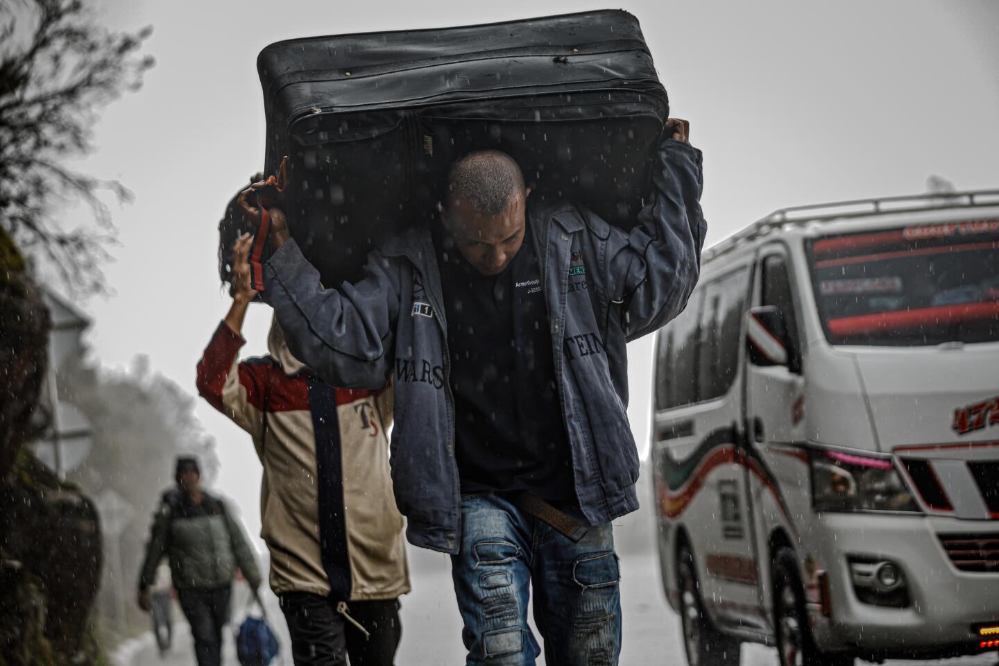 Venezuelan migrants walk through rain across a freezing plateau.