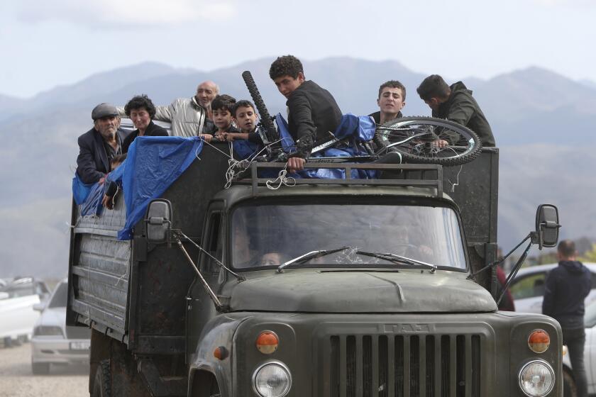 FILE - Ethnic Armenians from Nagorno-Karabakh ride a truck on their way to Kornidzor in Syunik region, Armenia, Sept. 26, 2023. Thousands of Nagorno-Karabakh residents are fleeing their homes after Azerbaijan's swift military operation to reclaim control of the breakaway region after a three-decade separatist conflict. (Stepan Poghosyan, Photolure photo via AP, File)