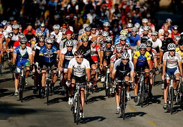 Lance Armstrong, center, in a yellow-streaked helmet and black shirt, leads a pack of cyclists on a three laps around Griffith Park. Armstrong brought the masses together by using Twitter, and they responded bright and early in the parking lot of the Los Angeles Zoo. Story: Cyclists love this Lance encounter