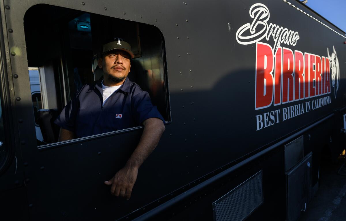 Taco truck owner Bryan Tecun sits in the driver's seat of his truck.