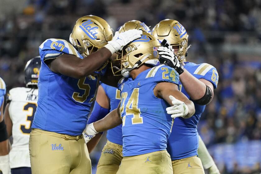 UCLA running back Zach Charbonnet, center, celebrates his touchdown with teammates during the second half of an NCAA college football game against California Saturday, Nov. 27, 2021, in Pasadena, Calif. UCLA won 42-14. (AP Photo/Jae C. Hong)
