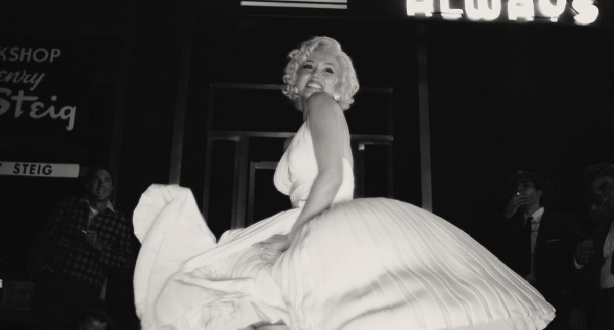 A black-and-white image of a blond woman posing in a billowing, white dress in the movie "Blonde." 