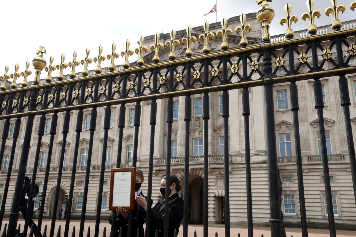 A small placard is affixed to the Buckingham Palace gates