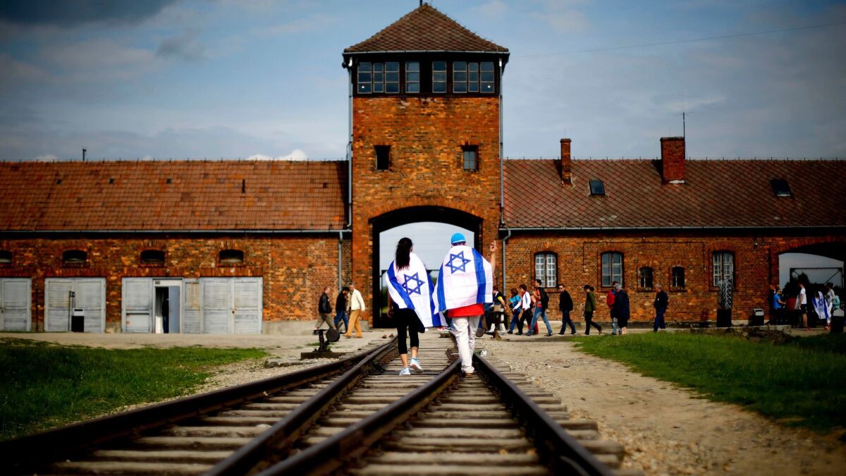 Visitors walk on railway tracks on the grounds of the former Nazi death camp Auschwitz-Birkenau near Oswieciem, Poland, in June 2015.