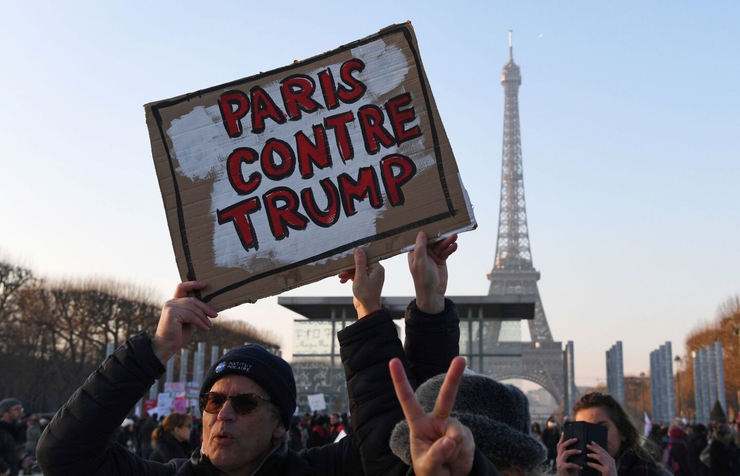 A demonstrator carries a sign reading "Paris against Trump" during a rally in France's capital in solidarity with supporters of the Women's March on Washington.