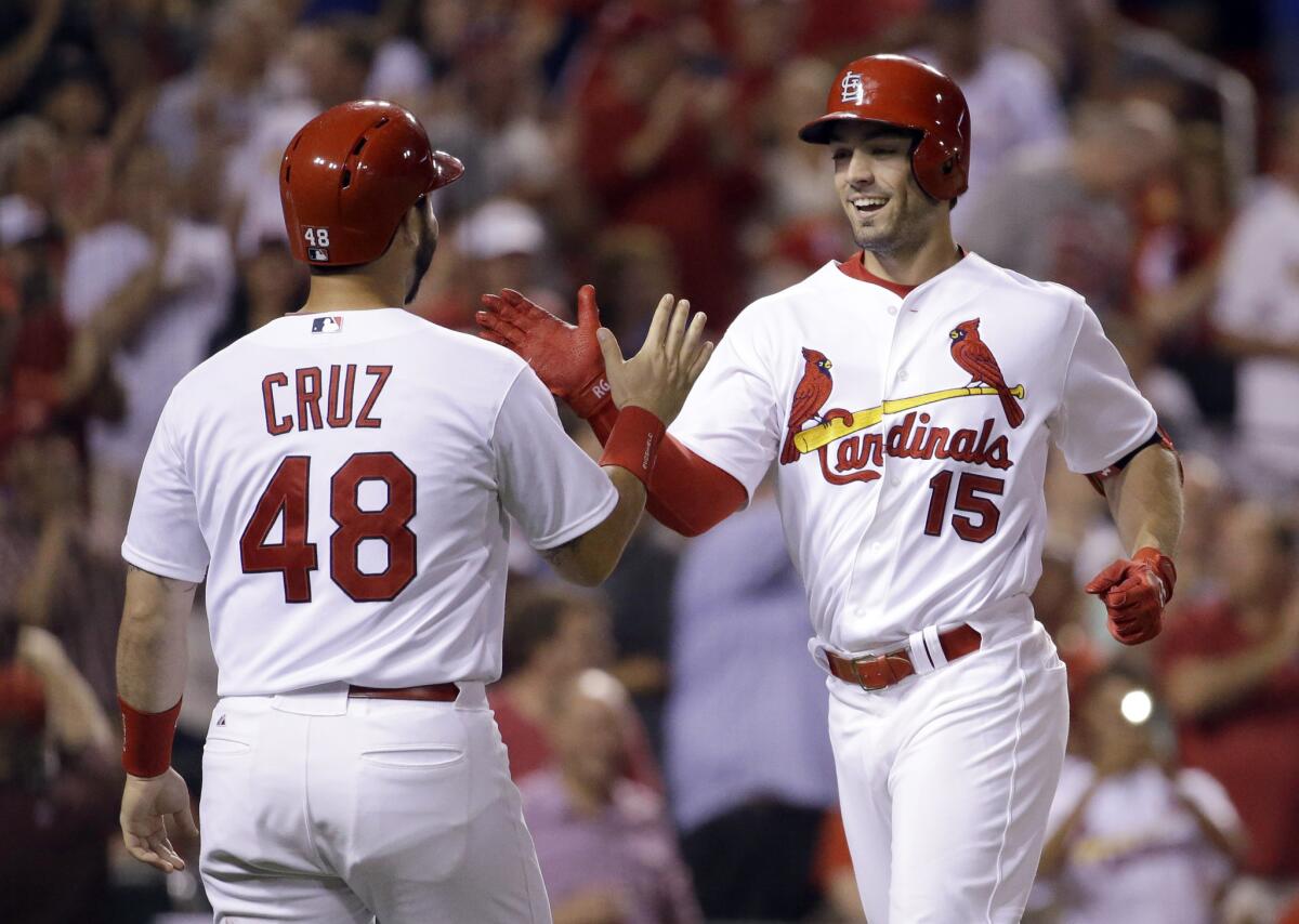 Cardinals center fielder Randal Grichu is congratulated by teammate Tony Cruz after hitting a two-run home run against the Cubs on Tuesday.