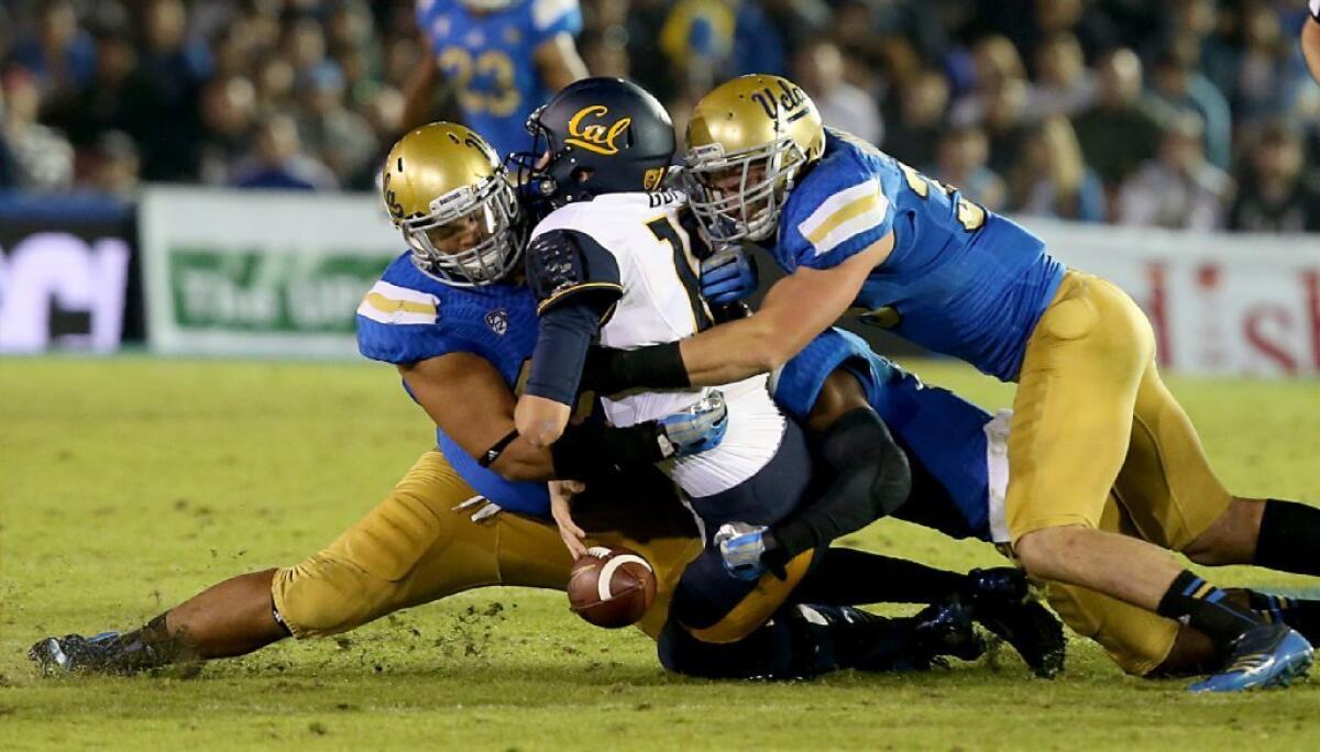 UCLA's Eddie Vanderdoes, left, and Jordan Zumwalt tackle Cal quarterback Jared Goff last October.
