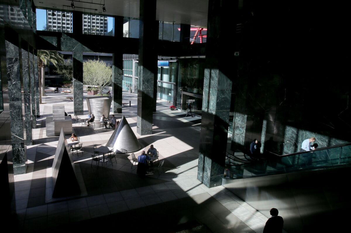 People meet, dine and walk around the shadows and sculptures in the covered plaza outside the Citigroup Center.