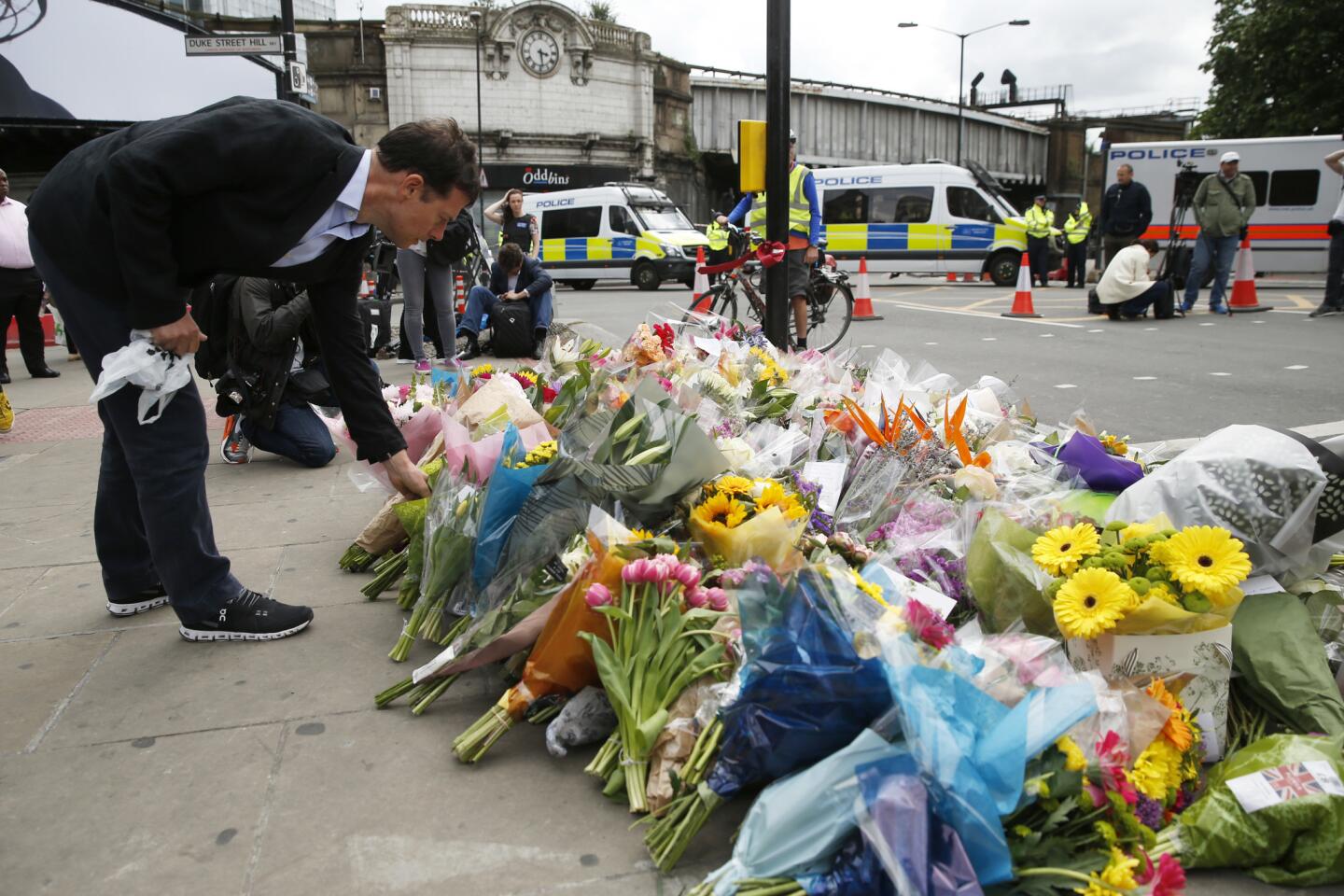 A man leaves flowers at a tribute in the London Bridge area on June 5.