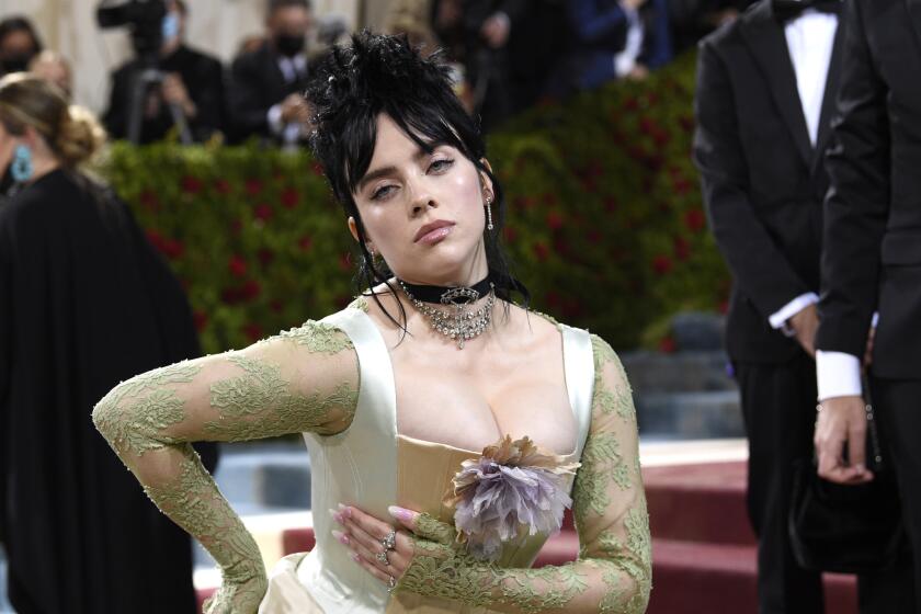 A woman with black hair poses in an old-fashioned corset dress