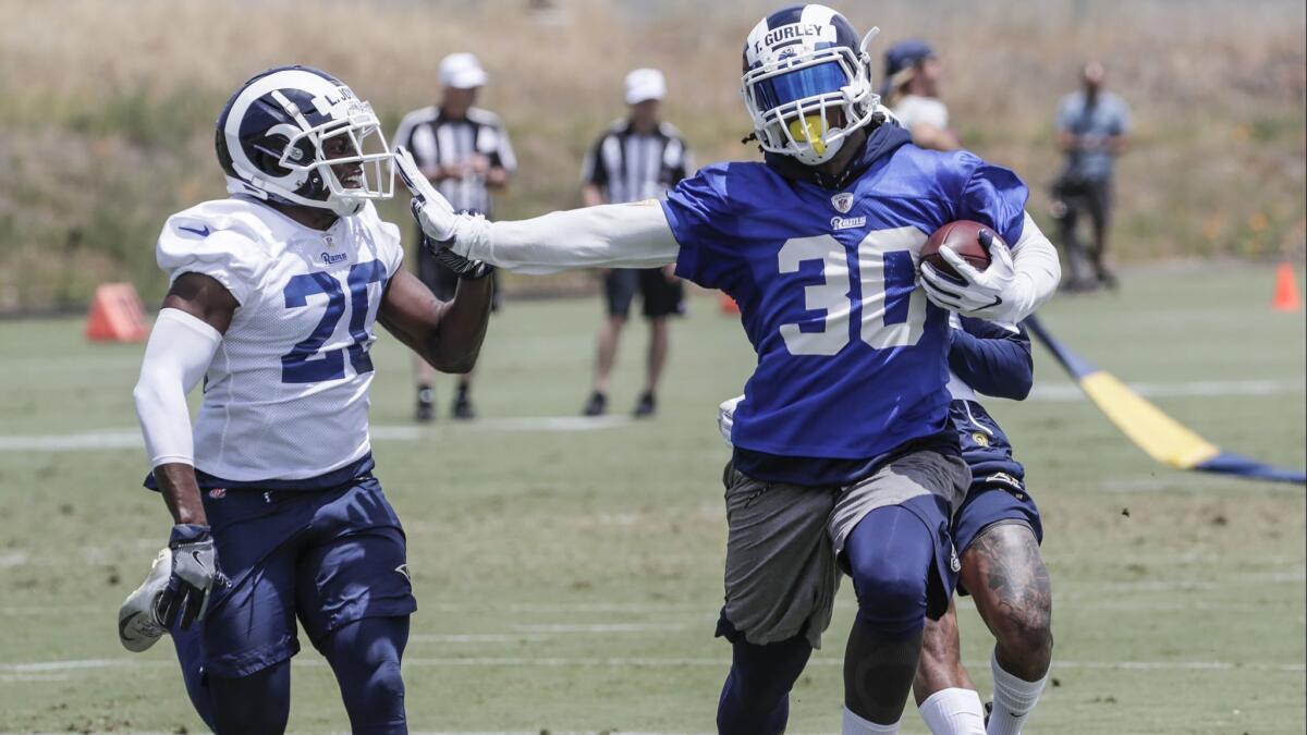 Rams running back Todd Gurley runs past safety Lamarcus Joyner during practice at Cal Lutheran University.