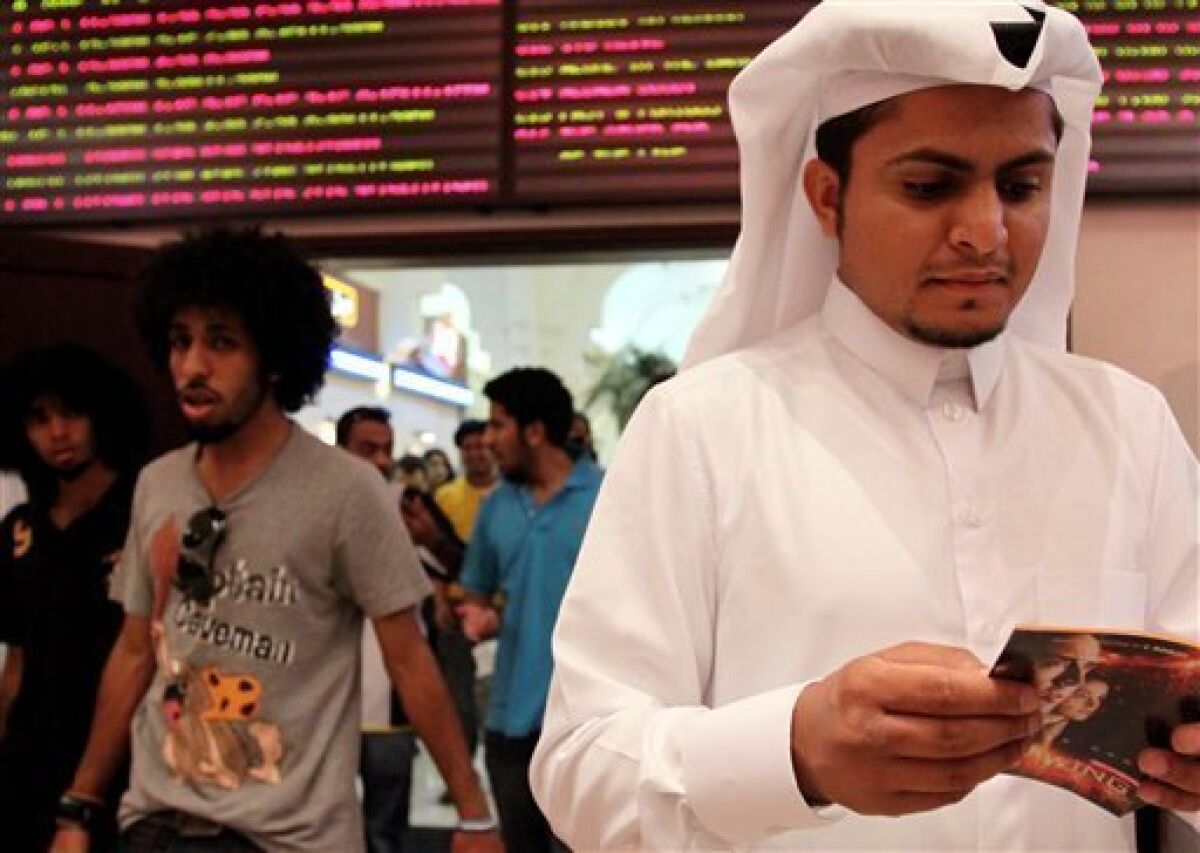 In this photo taken on May 7, 2009, Walid al-Musharraf, 27, of Riyadh, Saudi Arabia, looks at a brochure outside a Manama, Bahrain, movie theater. Al-Musharraf says he likes to watch foreign films and sees no reason his country should not have cinemas, noting that movies can be educational. Bahrain is trying to shed its image as a decadent hotspot of sin for Saudis, but plenty of tourists from this conservative region come for much tamer fare _ Hannah Montana, heavy metal and relaxed family entertainment. (AP Photo/Hasan Jamali)