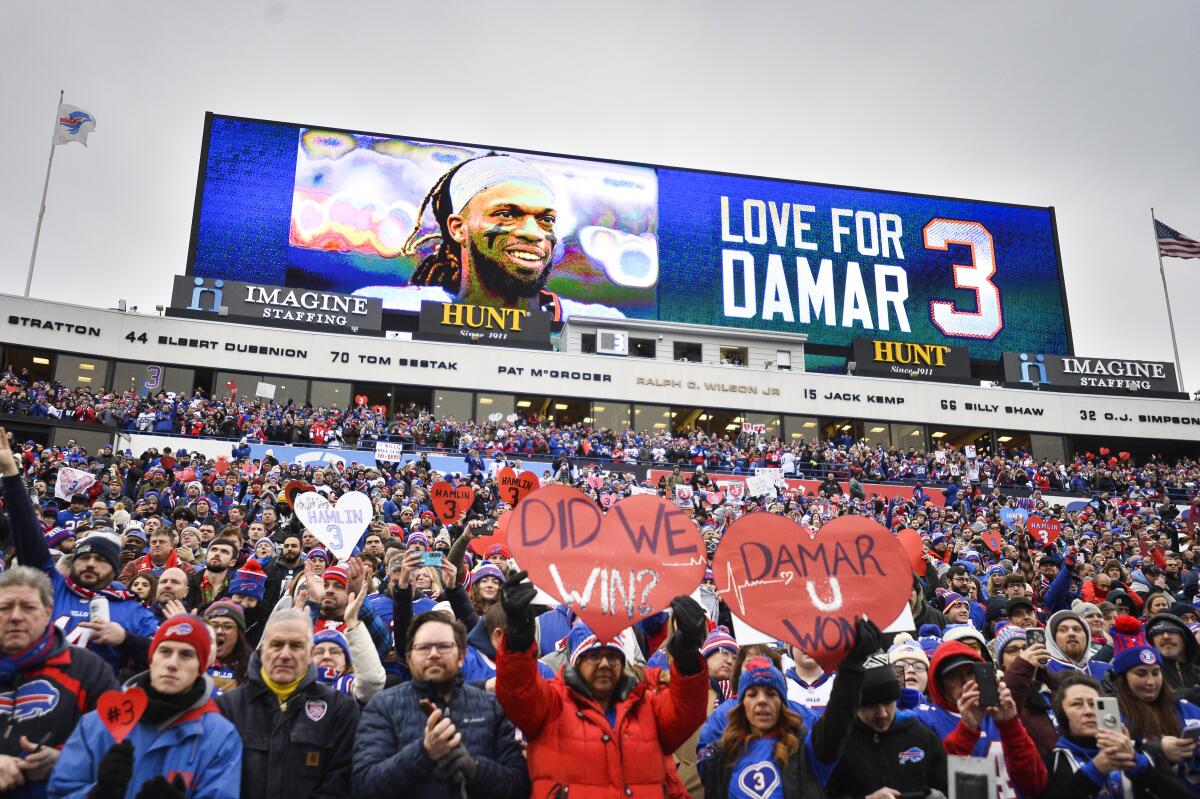 Fans stand in support for Buffalo Bills safety Damar Hamlin (3) before an NFL football game against the New England Patriots