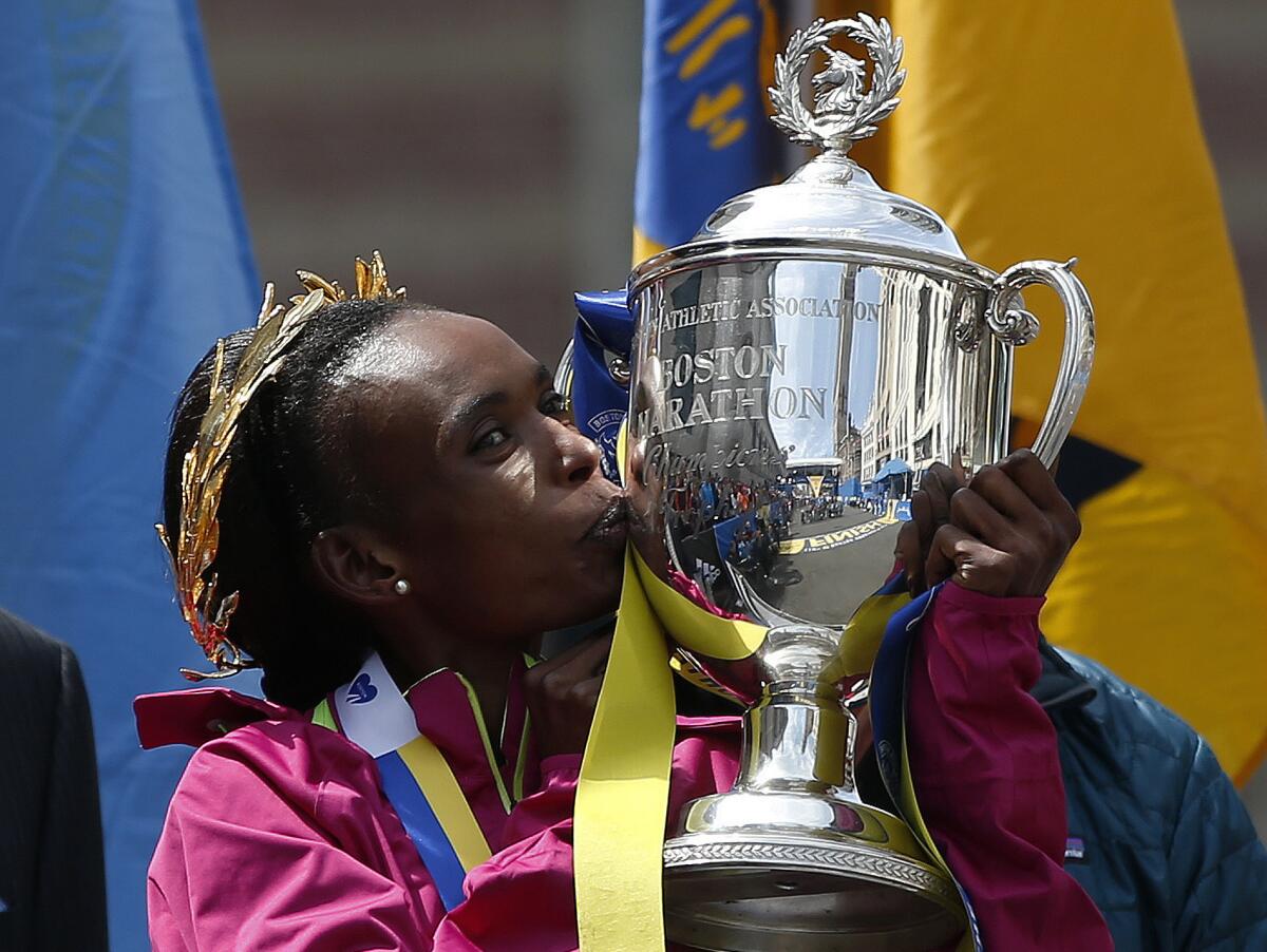 Rita Jeptoo kisses the trophy after winning the women's division of the Boston Marathon on April 21, 2014.