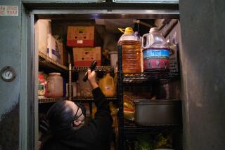 Ngoc McShane, environmental health specialist, uses a flashlight to inspect the walk-in fridge at The Great Grill in Burbank on April 13, 2023. The restaurant maintained an A score after the inspection. (Alisha Jucevic/For The Times)