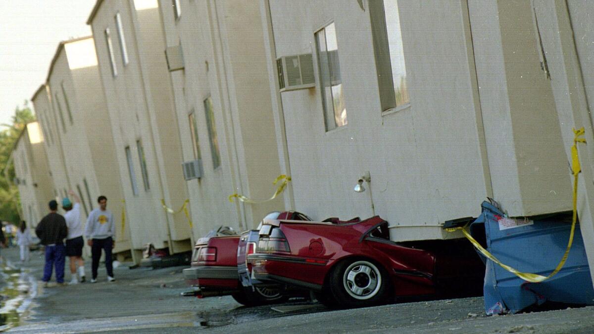 Cars sit underneath a collapsed apartment building after the 1994 Northridge earthquake.