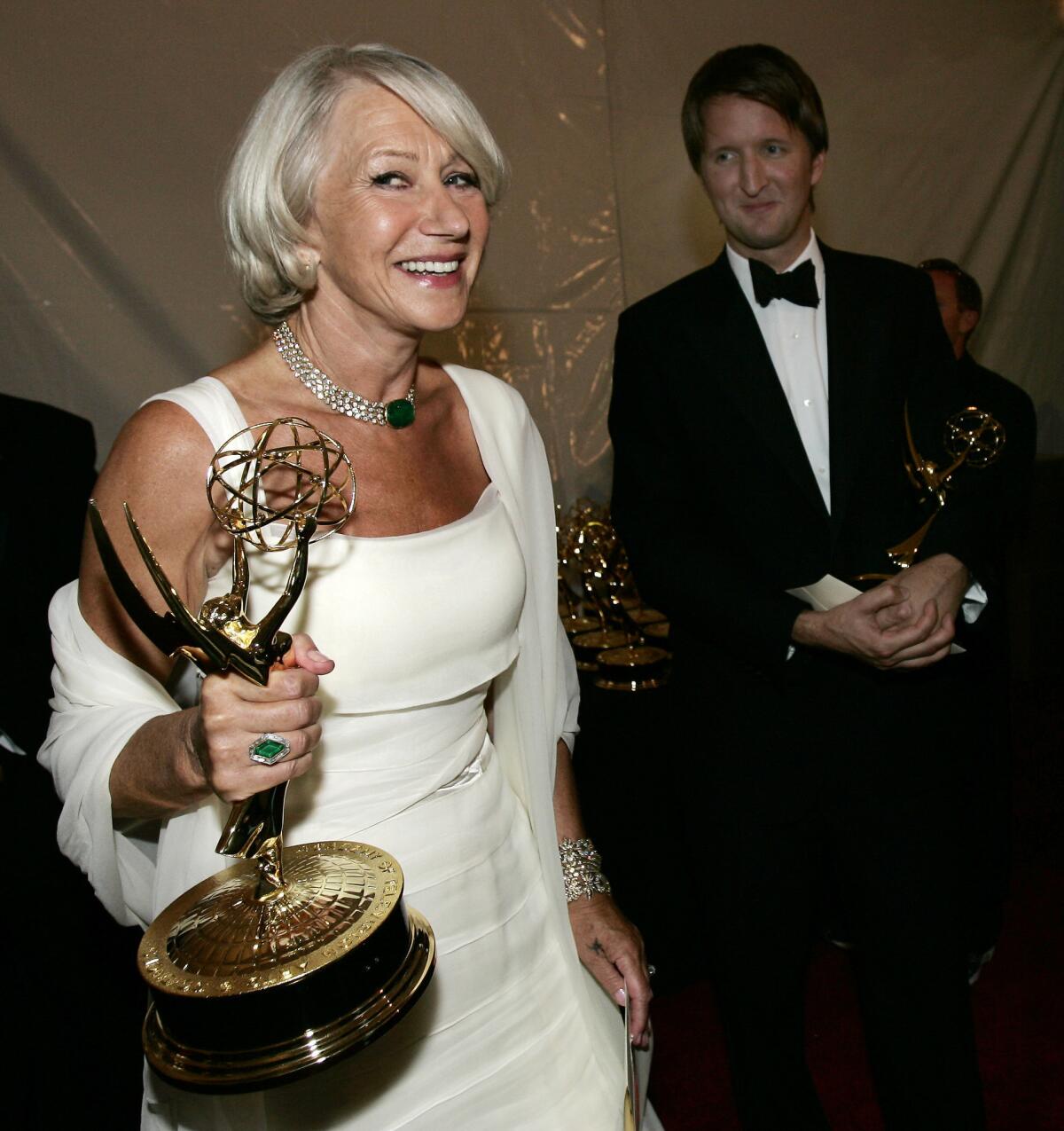 British actress Helen Mirren hold her Emmy for outstanding lead actress in a miniseries or a movie for her work on "Elizabeth I" backstage at the 58th Annual Primetime Emmy Awards Sunday, Aug. 27, 2006, in Los Angeles. Director Tom Hooper is in the background.