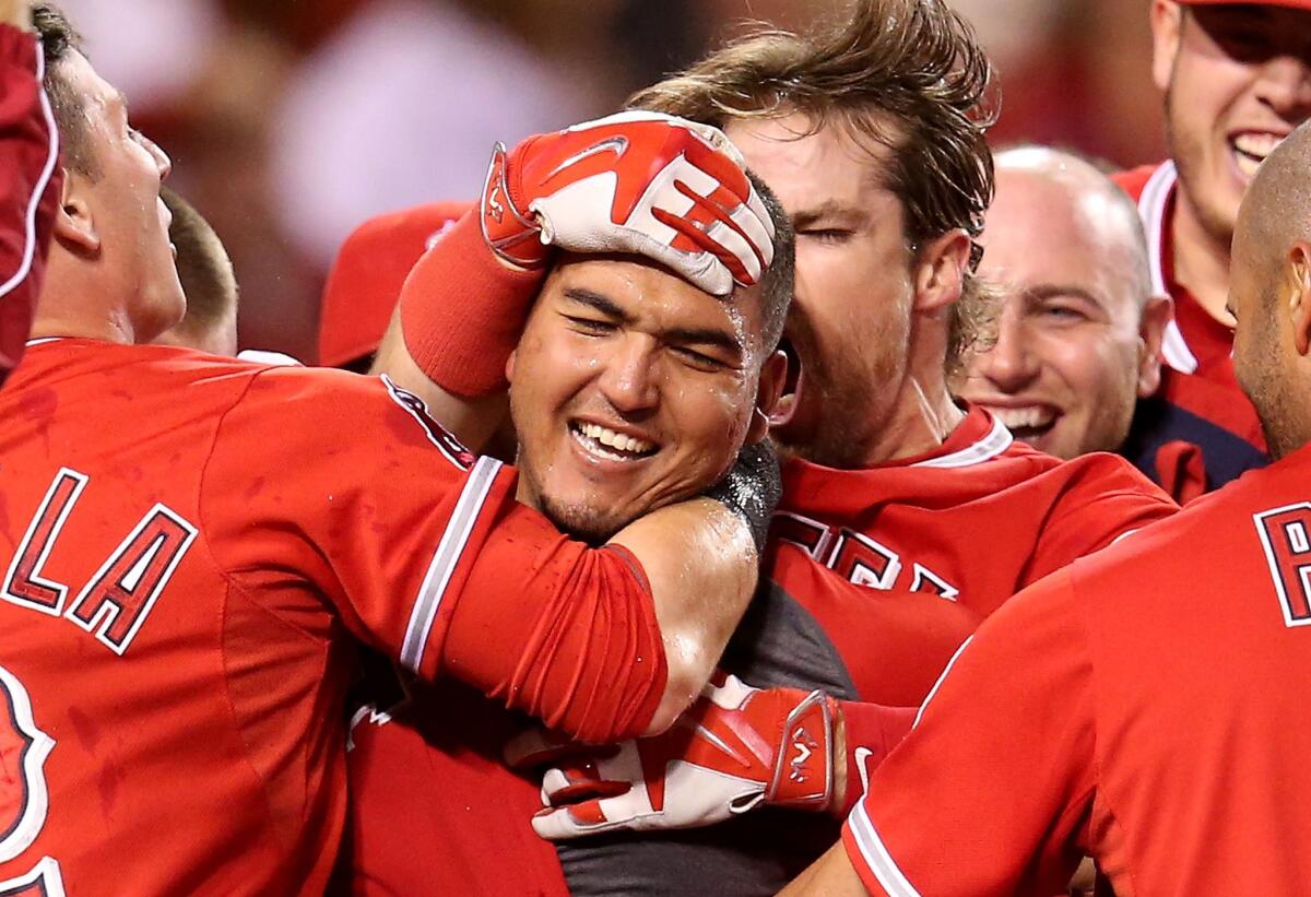Catcher Carlos Perez is mobbed by his Angels teammates after hitting a walk-off home run in his major league debut. The Angels beat the Seattle Mariners, 5-4.
