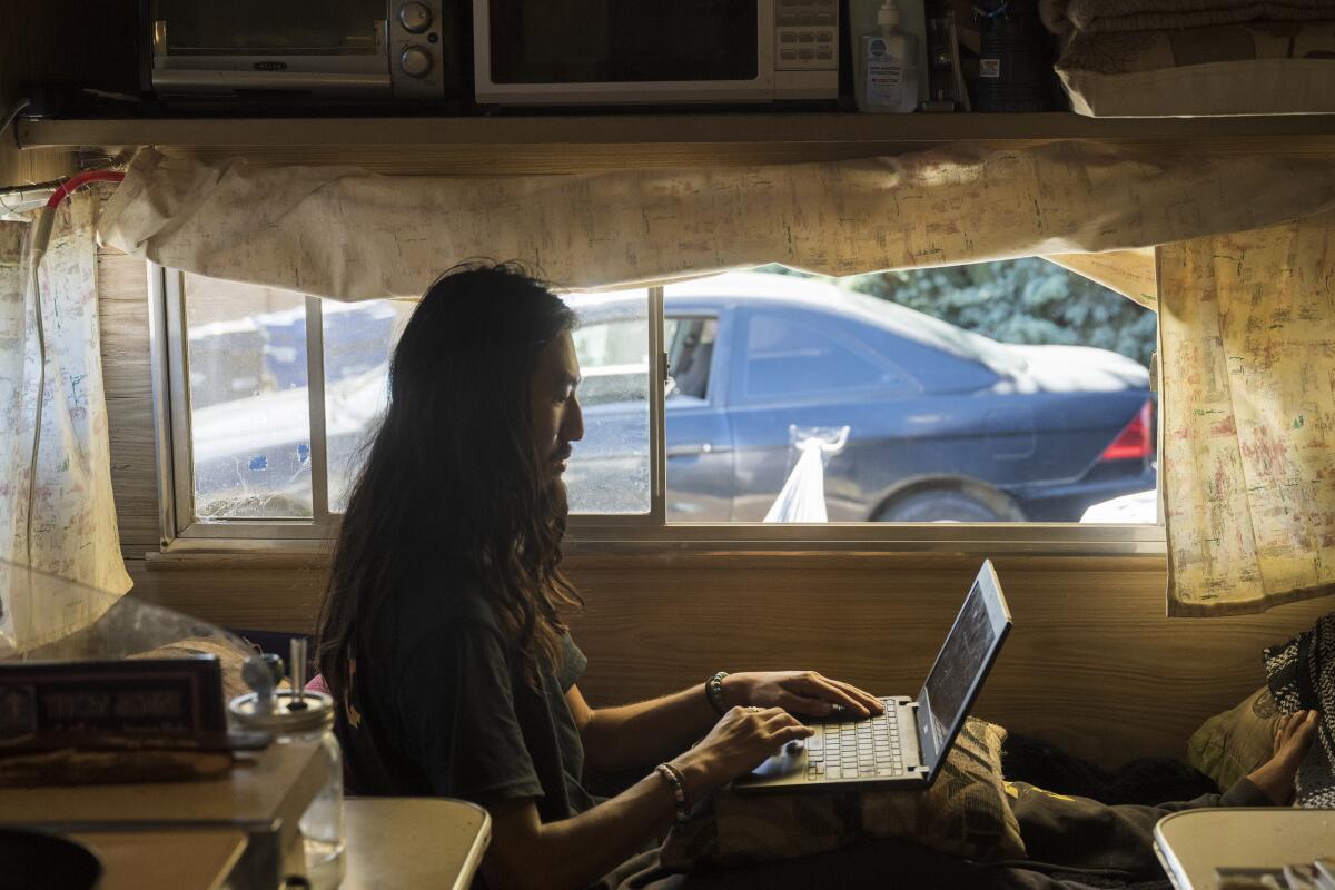 Matthew, a University of California Santa Cruz student, in a trailer with his computer