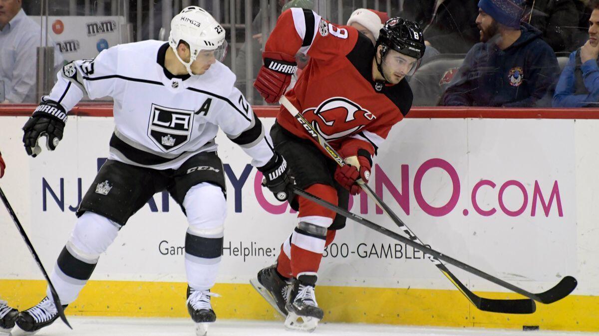 New Jersey Devils defenseman Will Butcher gets by Kings right wing Dustin Brown during a Dec. 12 game in Newark, N.J.