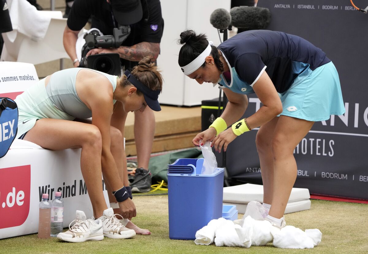 Ons Jabeur from Tunesia, right, helps to Belinda Bencic from Switzerland after sustaining an injury during the WTA tournament final tennis match in Berlin, Germany, Sunday, June 19, 2022. (AP Photo/Michael Sohn)
