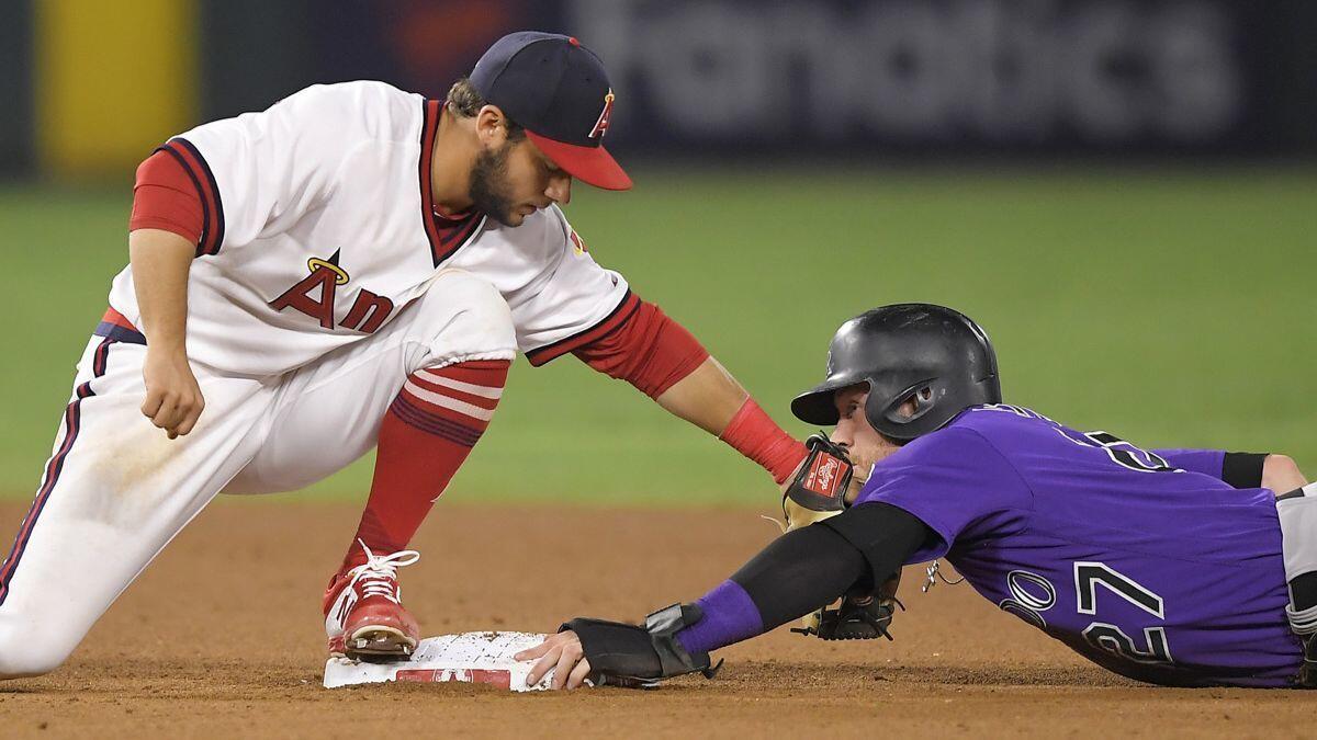 Angels shortstop David Fletcher, left, puts a late tag on Colorado Rockies' Trevor Story as Story steals second during the seventh inning on Tuesday.