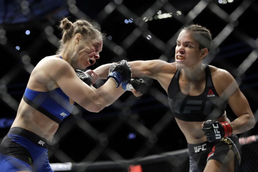 Amanda Nunes connects with an overhand right against Ronda Rousey during their women's bantamweight championship fight at UFC 207.