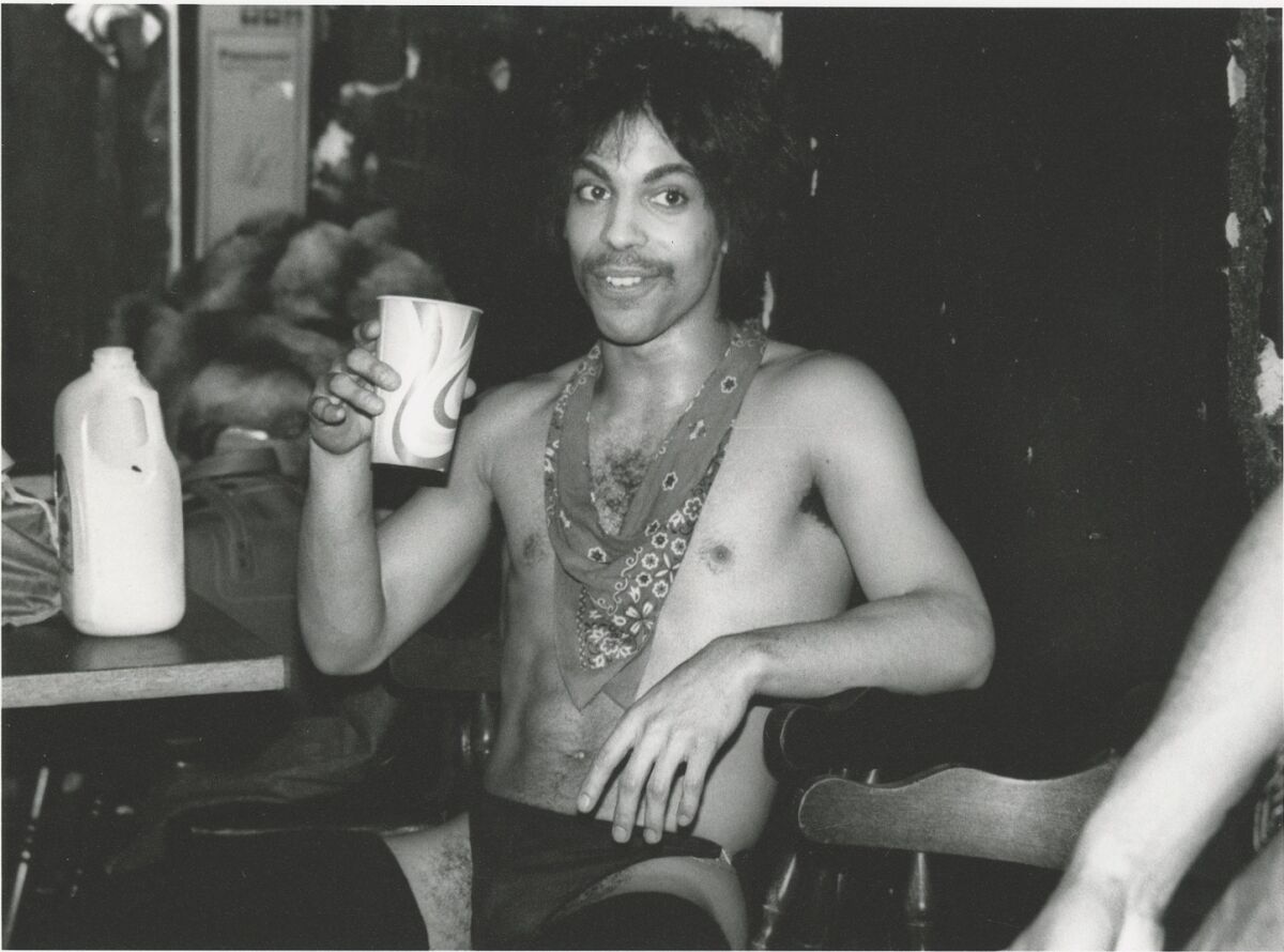 Prince sips orange juice backstage during the 1981 Dirty Mind tour, featured in “The Beautiful Ones.” 