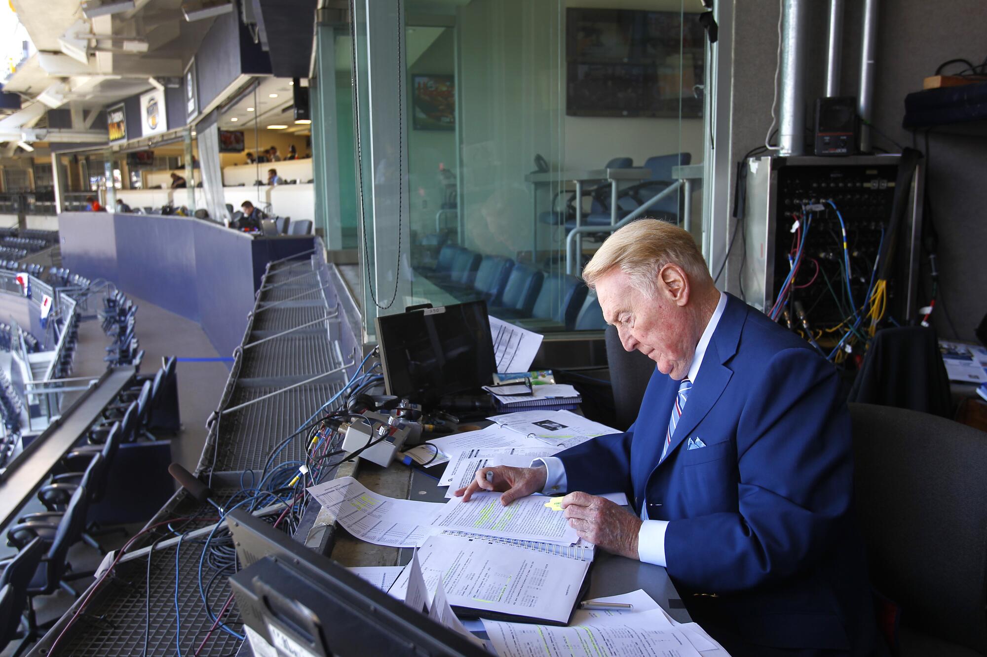 Dodgers announcer Vin Scully looks over his notes in the announcer's booth before a game.