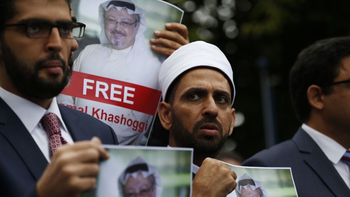 Members of the Turkish-Arab Journalist Assn. hold posters with photos of missing Saudi writer Jamal Khashoggi on Monday as they protest near the Saudi Arabian Consulate in Istanbul, Turkey.